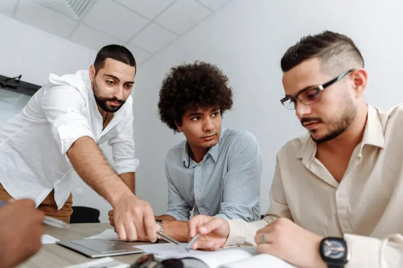 Three colleagues working together at a desk